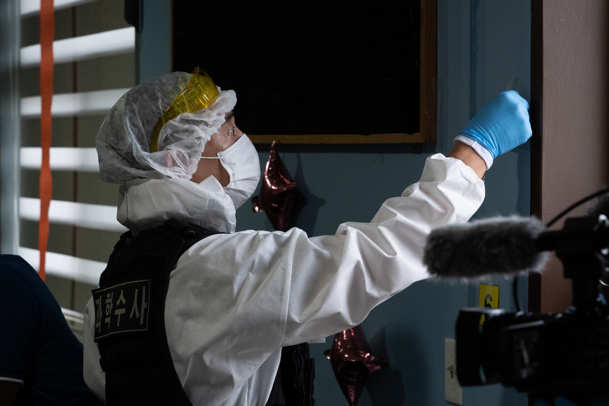 A crime scene investigator marks simulated evidence during a training scenario.