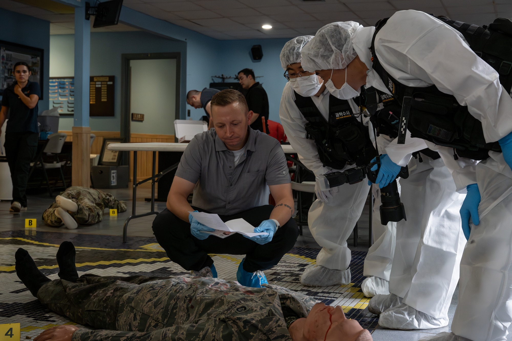 U.S. and ROK Airmen search a mannequin during a joint crime scene training.