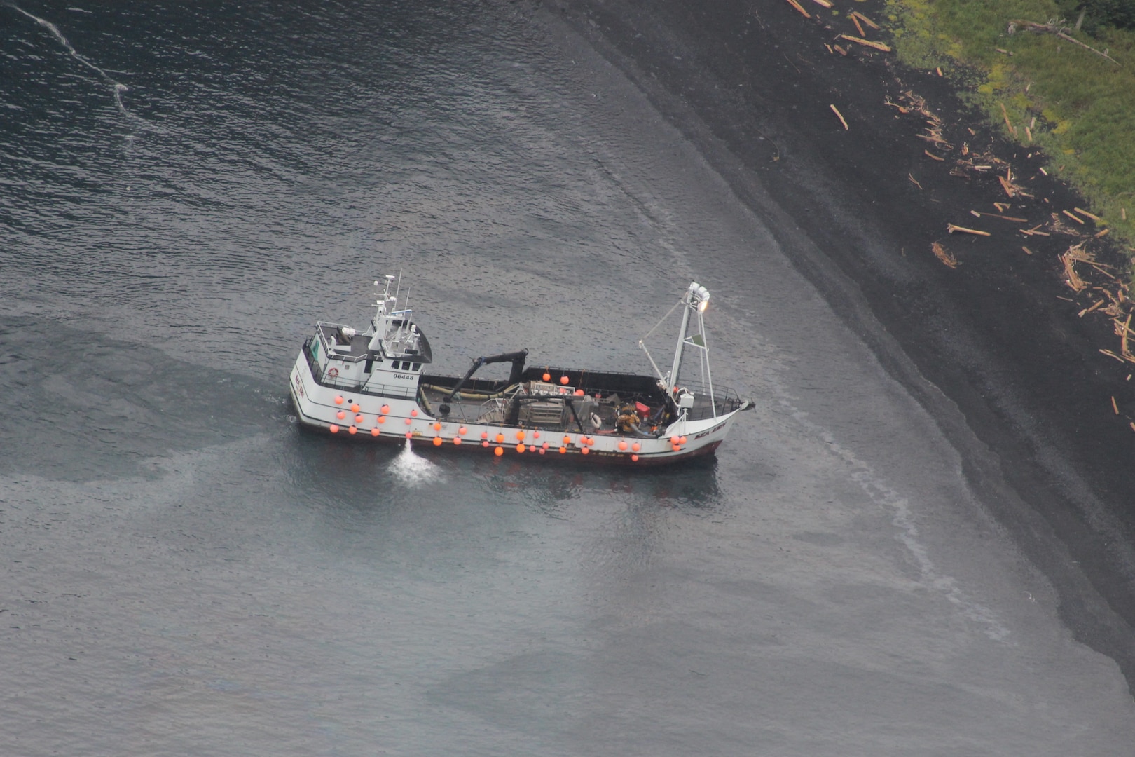 An aircrew from Coast Guard Air Station Kodiak conducts an overflight of a fishing vessel that ran aground in Izhut Bay, Kodiak, Alaska, Sept. 1, 2025. The Coast Guard is responding to the diesel released from the vessel. (U.S. Coast Guard courtesy photo