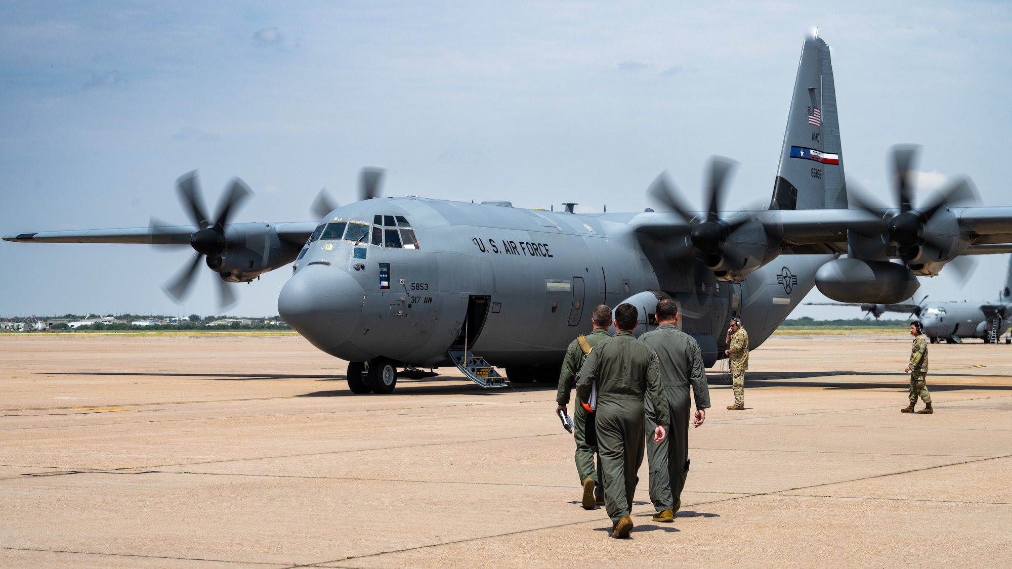 U.S. Air Force Gen. Johnny Lamontagne, Air Mobility Command commander, and 317th Airlift Wing leadership walk toward a C-130J Super Hercules at Dyess Air Force Base, Texas, Aug. 26, 2025. During his visit to Dyess, the 317th AW showcased their critical combat airlift capabilities to the AMC command team. (U.S. Air Force photo by Senior Airman Jade M. Caldwell)