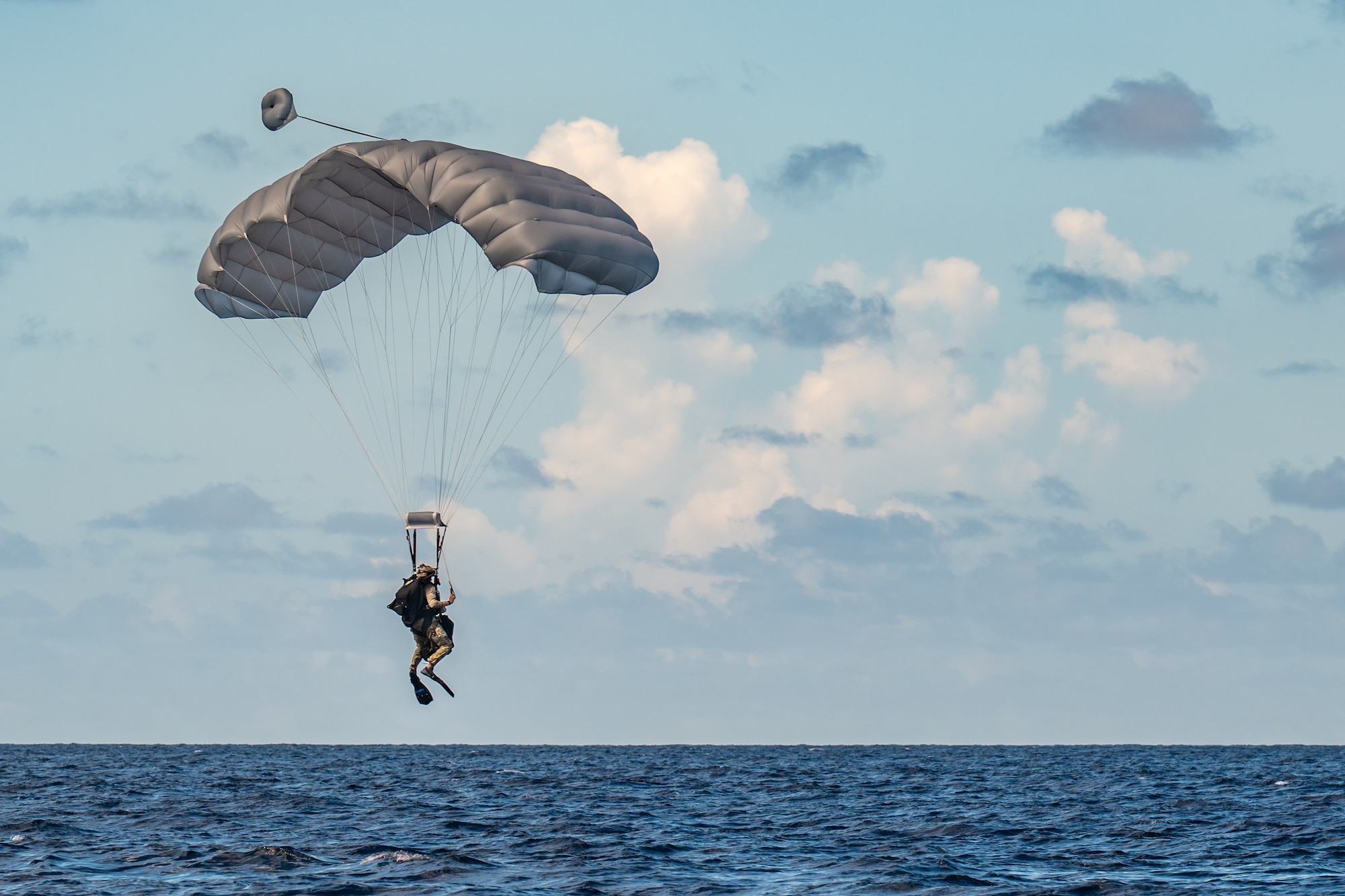 A U.S. Air Force special tactics Airman from the Kentucky Air National Guard’s 123rd Airlift Wing parachutes into the Caribbean Sea to conduct a search-and-rescue mission for the survivors of a simulated plane crash off the coast of St. Croix, U.S. Virgin Islands, Aug. 29, 2025 as part of Emerald Warrior 25.2, a large-scale special operations exercise staged in multiple locations by Air Force Special Operations Command. St. Croix provides an ideal environment for testing littoral and maritime capabilities, simulating many of the geographic features that special operators may encounter when deployed around the world to project air power in unfamiliar or contested environments. (U.S. Air National Guard photo by Dale Greer)