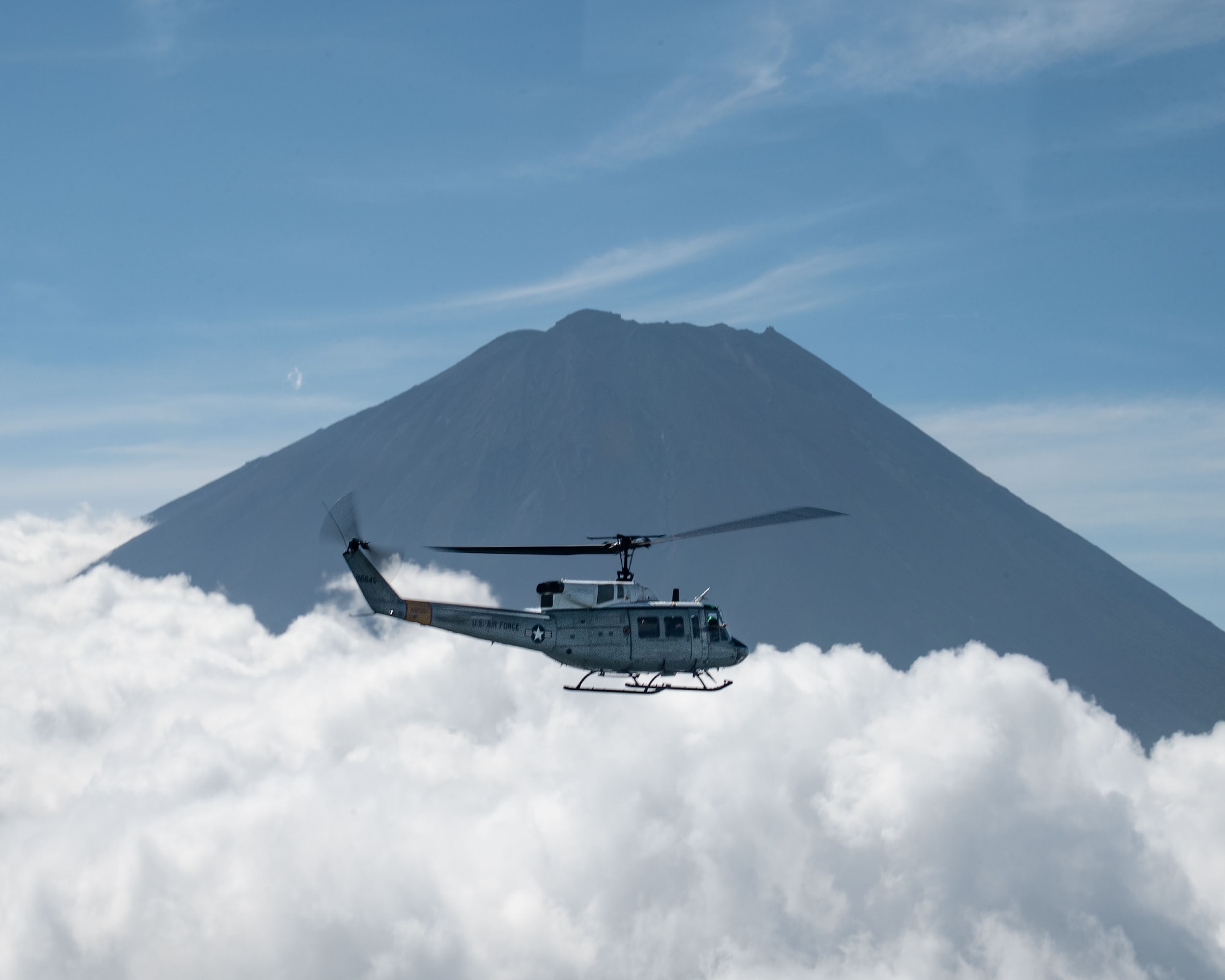 A helicopter flies in front of a mountain