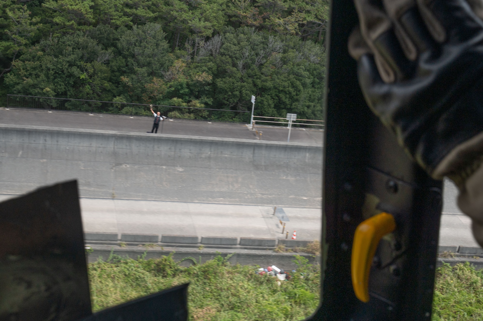 A person waves to a helicopter in the sky