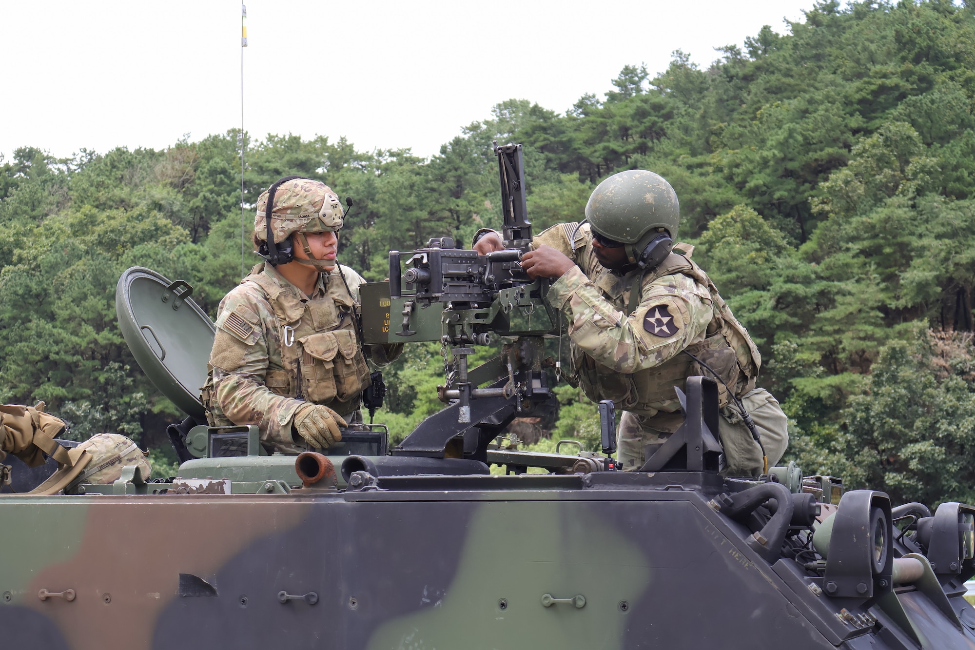 Two men work on a tank.