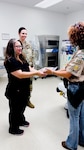 Winn Army Community Hospital ER clinical nurse supervisor Melissa Hungerford accepts one of more than 100 Better Bears from Life Scout Reis Hill as Lt. Col. Brittany Kull, Winn’s chief of hospital education, looks on. Reis created the bears for her Eagle Scout project to help comfort children visiting the ER.