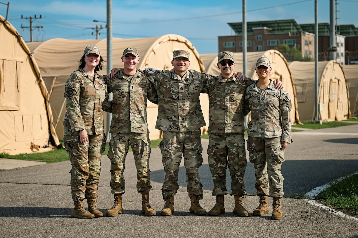 5 service members pose for a group photo