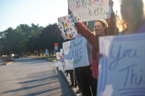 Image of volunteers holding signs of encouragement during a National Suicide Prevention Month awareness event.