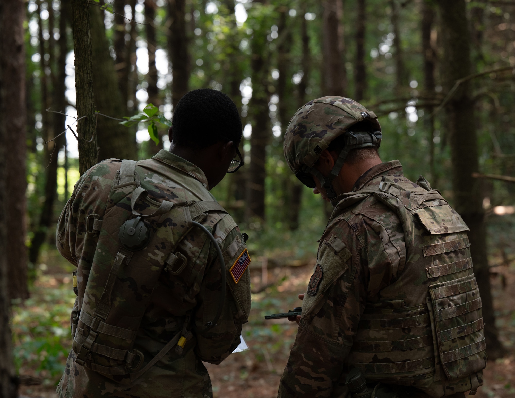 U.S. Army Spc. Demi Douglas, 304th Transportation Company chemical, biological, radiological, and nuclear specialist, and U.S. Air Force Tech. Sgt. Wesly Jones, 439th Civil Engineering Squadron emergency management specialist, discusses land navigation strategies during Eastern Nexus July 26, 2025, Westover Air Reserve Base, Mass. Eastern Nexus is a graded combat readiness exercise designed to test mission essential tasks during joint operations in a simulated deployed environment. (U.S. Air Force photo by Airman 1st Class Jah’nae Holmes)