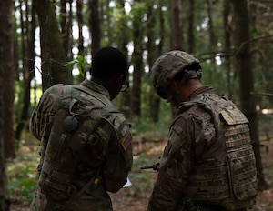 U.S. Army Spc. Demi Douglas, 304th Transportation Company chemical, biological, radiological, and nuclear specialist, and U.S. Air Force Tech. Sgt. Wesly Jones, 439th Civil Engineering Squadron emergency management specialist, discusses land navigation strategies during Eastern Nexus July 26, 2025, Westover Air Reserve Base, Mass. Eastern Nexus is a graded combat readiness exercise designed to test mission essential tasks during joint operations in a simulated deployed environment. (U.S. Air Force photo by Airman 1st Class Jah’nae Holmes)