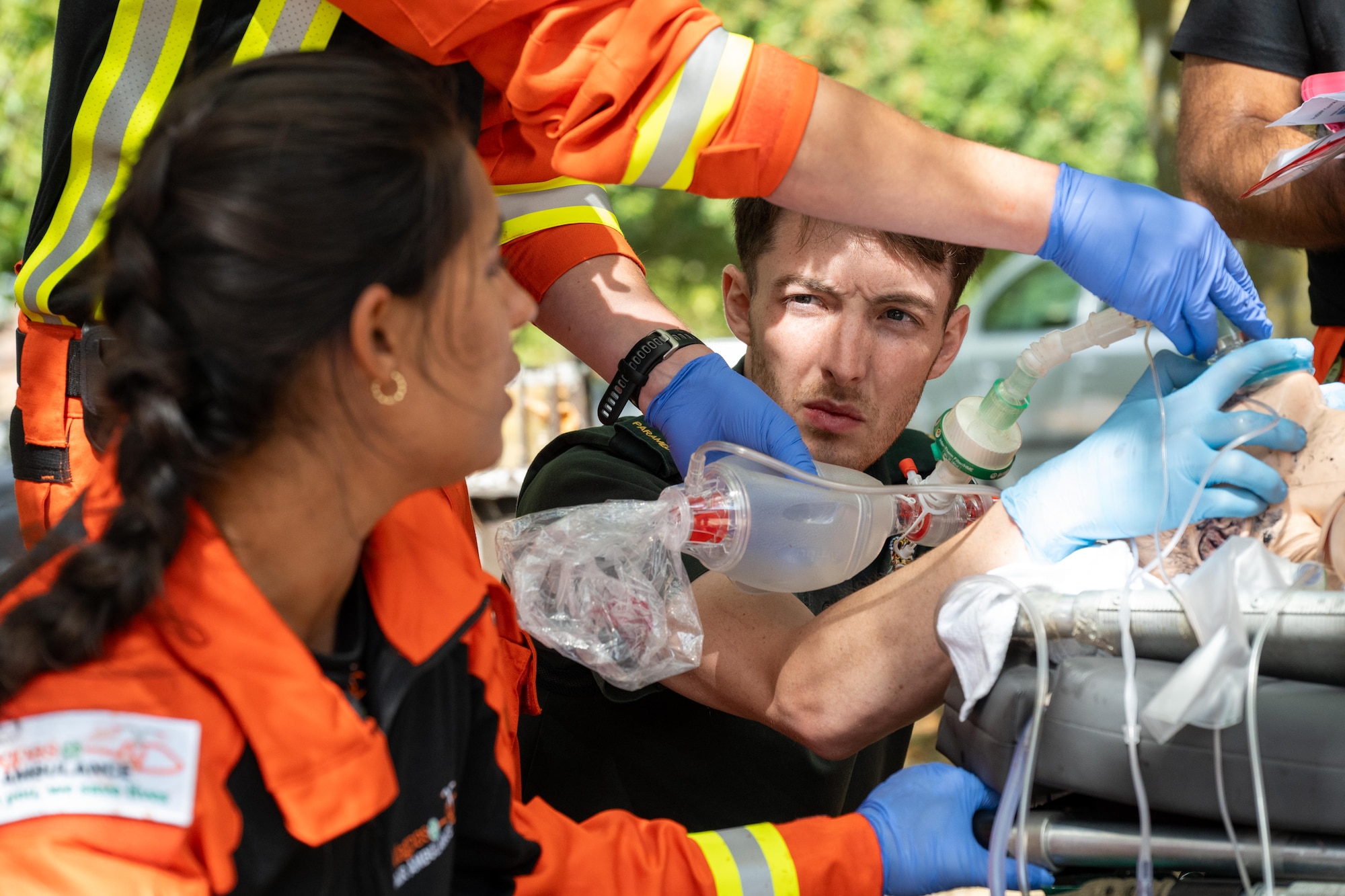 A UK paramedic assists with airway management while treating a simulated casualty