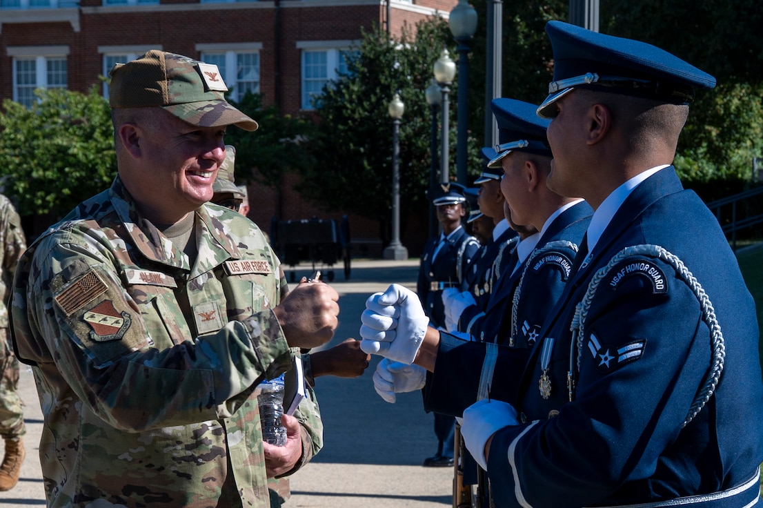 U.S. Air Force Col. James M. Clark, commander of Joint Base Anacostia-Bolling and the 11th Wing, fist bumps Airman 1st Class Gabriel Viloria, a ceremonial guardsman with the U.S. Air Force Honor Guard Firing Party, during an immersion tour at JBAB, Washington, D.C., Aug. 26, 2025. The tour gave new JBAB and Air Force District of Washington leadership firsthand insight on the operations of the Honor Guard whose mission is to deliver premier ceremonial honors, inspire the nation, and represent all Airmen and Guardians to the world. (U.S. Air Force photo by Hayden Hallman)