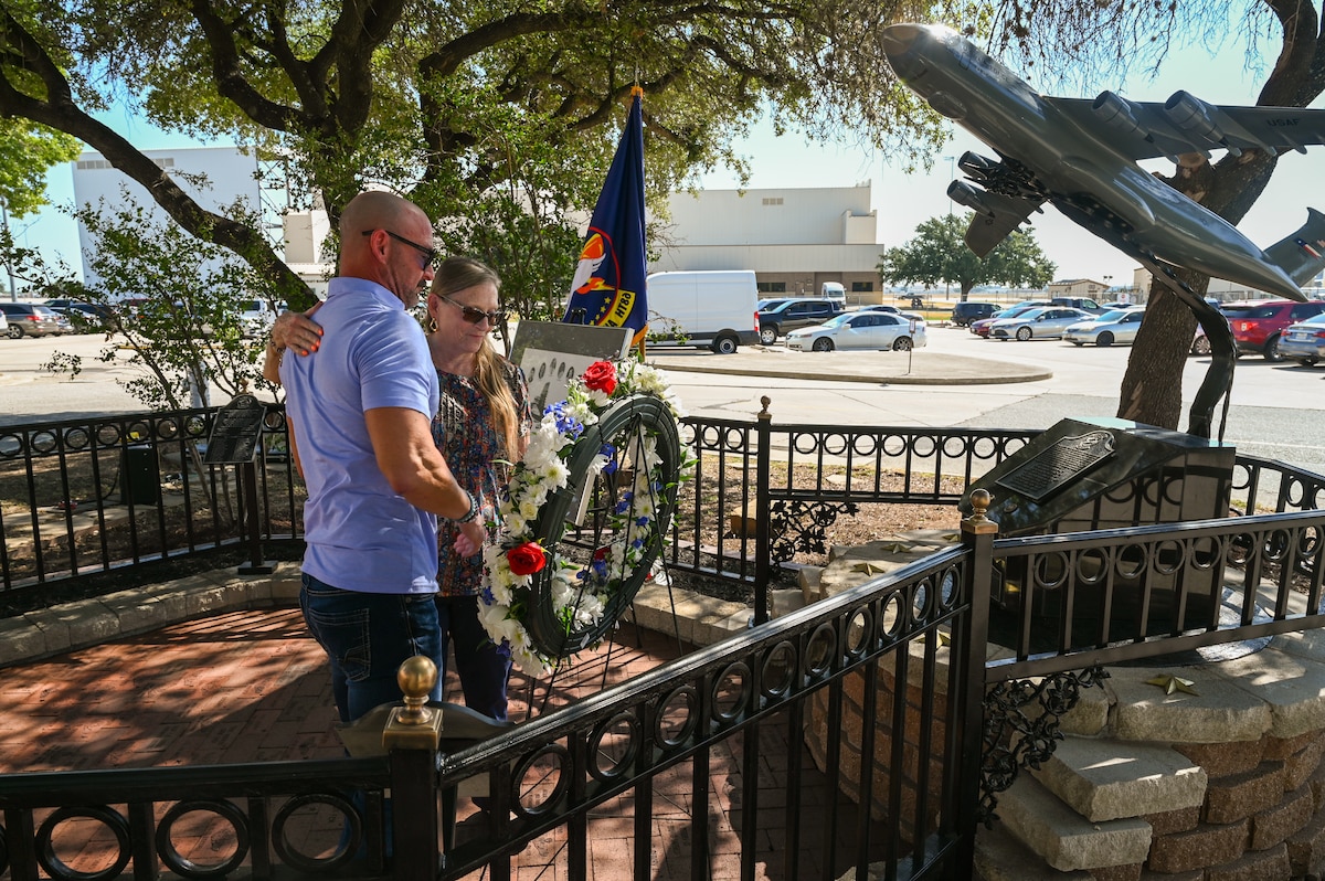 Anthony Price and his mother Susan Venuto embrace after placing a wreath at the BRAVO-12 memorial as part of a remembrance ceremony outside the 68th Airlift Squadron building on Joint Base San Antonio-Lackland, Texas Aug. 29, 2025.