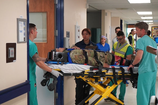 250821-N-FT324-3128. ROTA, SPAIN (August 21, 2025). Clinical staff at Naval Medical Readiness and Training Command (NMRTC) Rota receive a simulated casualty during a mass casualty joint training exercise. The exercise enhanced medical warfighter readiness by sharpening clinical teams’ ability to triage, stabilize, and provide critical care in a fast-paced, operational environment. (U.S. Navy photo by Lt. Cmdr. Jonathan Phillips)