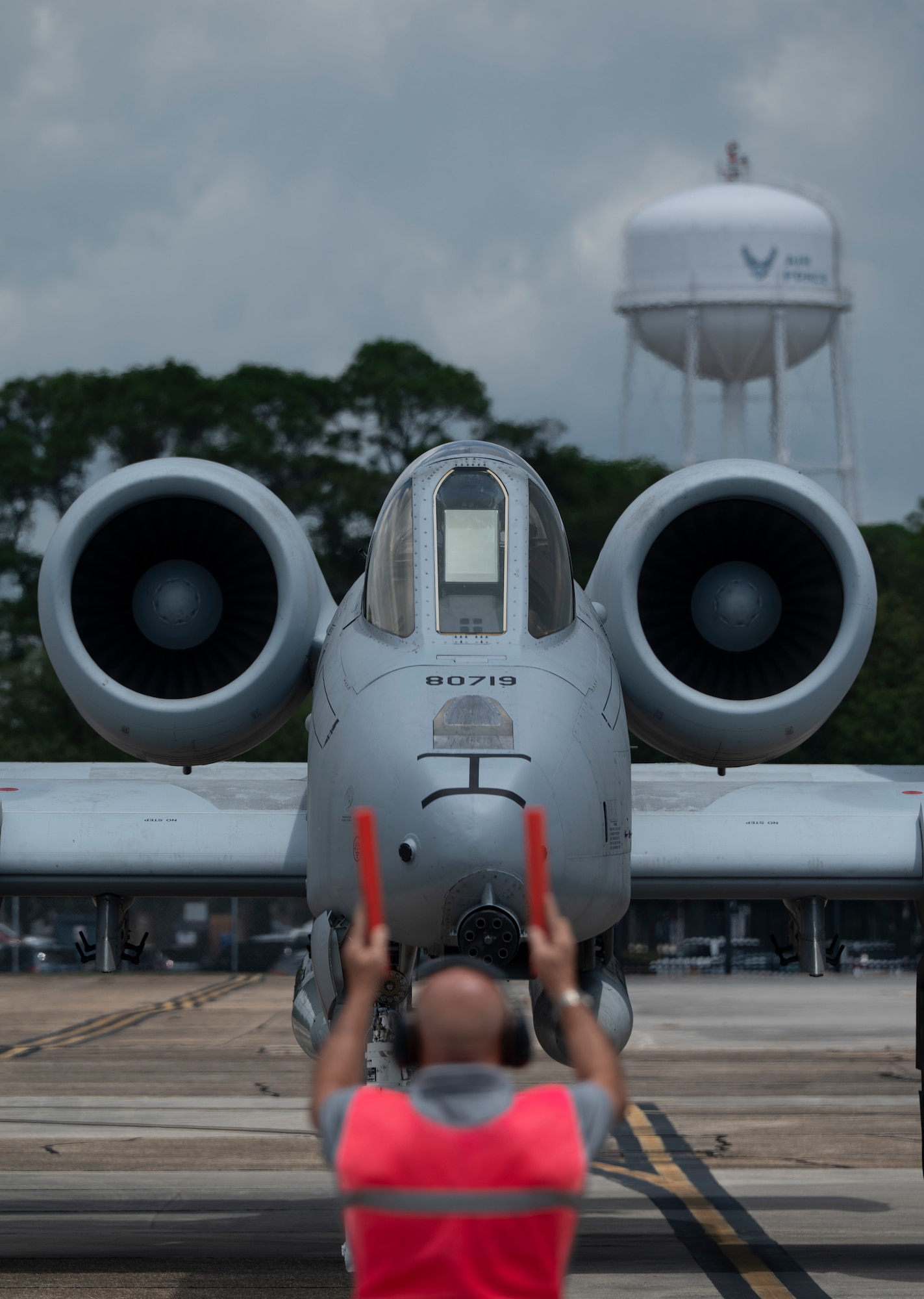 A military airplane taxis across an airfield.