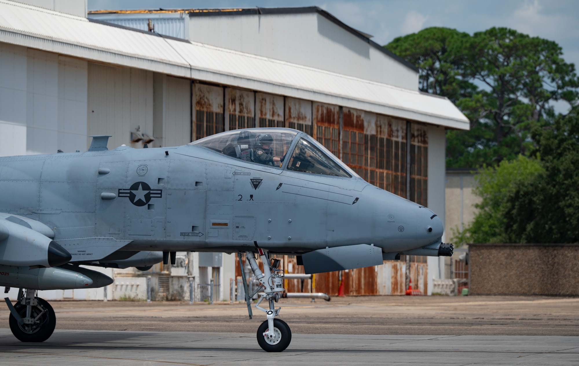 A military airplane taxis across an airfield.