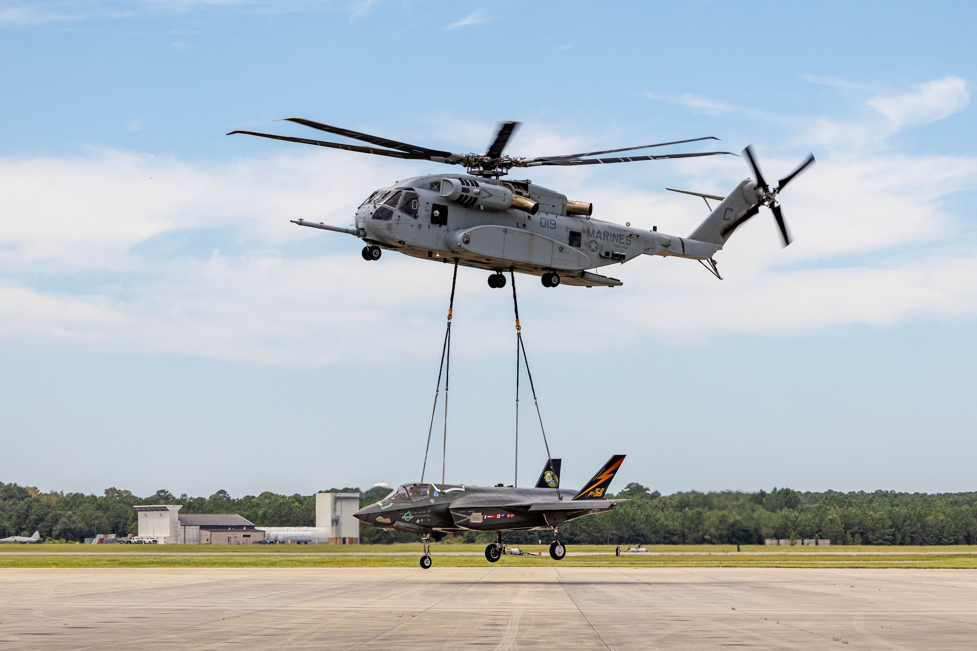 A U.S. Marine Corps heavy-lift Sikorsky CH-53K King Stallion helicopter with Marine Heavy Helicopter Squadron 461, Marine Aircraft Group 29, 2nd Marine Aircraft Wing, off-loads a F-35B Lightning II after a long-range external lift operation at Marine Corps Air Station Beaufort, South Carolina, Aug. 27, 2025. The F-35B Lighting II aircraft, known as BF-1, was the first F-35B Lightning II variant ever built, ushering in a new era for Marine Corps Aviation. (U.S. Marine Corps photo by Lance Cpl. Isabella Renaud)