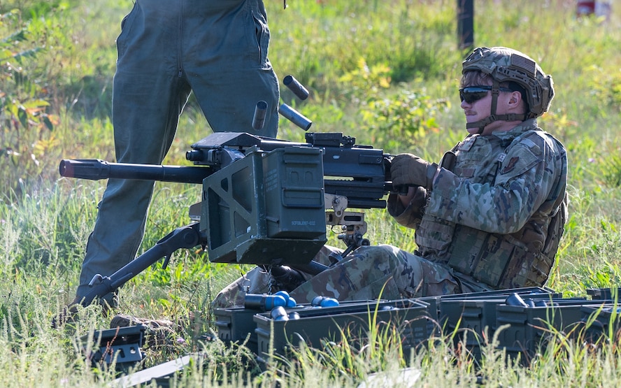 A defender Airman fires a Mk 19 automatic grenade launcher.