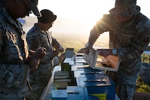 Defender Airmen load simulation rounds into magazines.