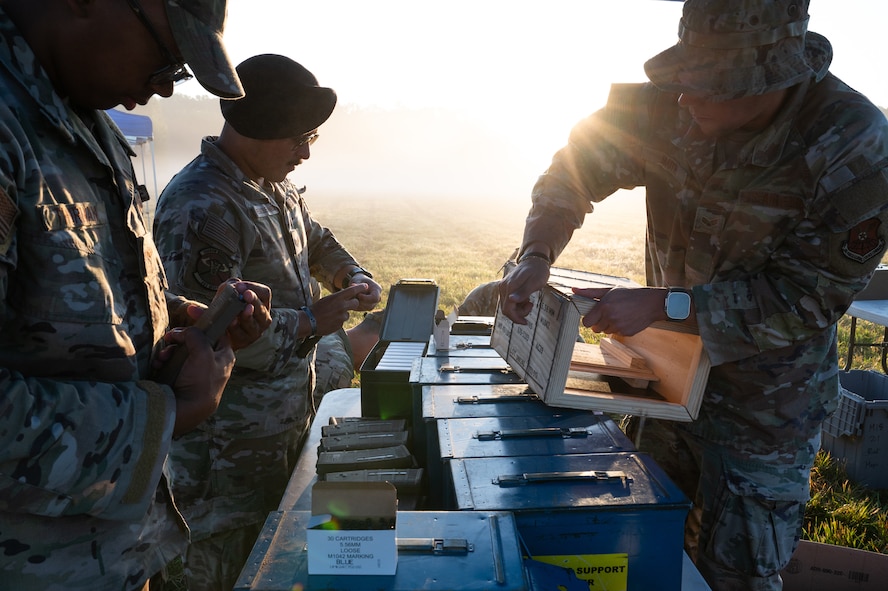 Defender Airmen load simulation rounds into magazines.