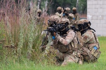 Defender Airmen post with weapons ready during a field training exercise.