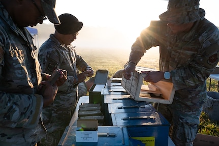 Defender Airmen load simulation rounds into magazines.