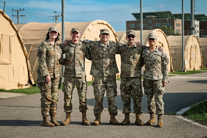 5 service members pose for a group photo