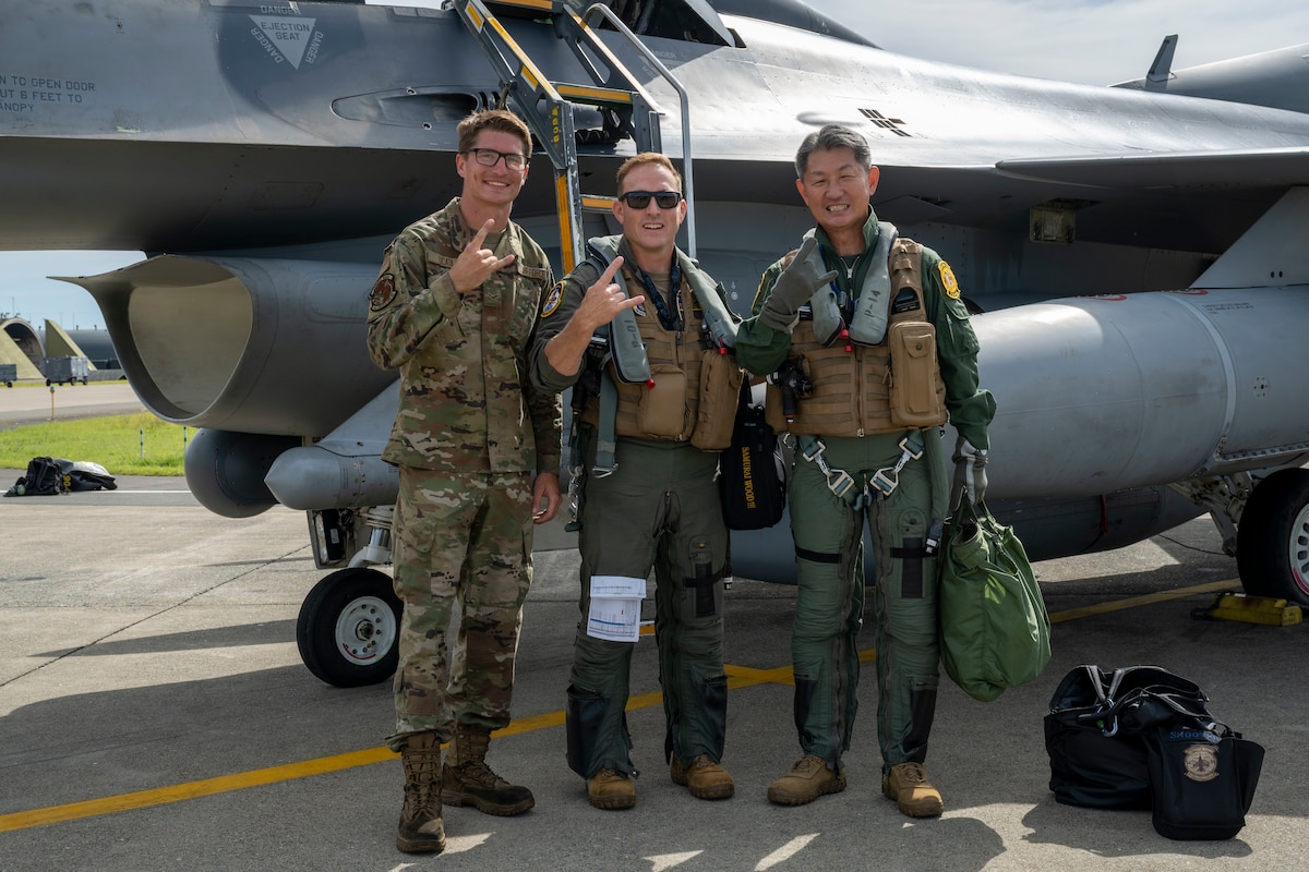 From right, Japan Air Self-Defense Force Maj. Gen. Teruaki Fujita, 3rd Air Wing commander, U.S. Air Force Col. Paul Davidson, 35th Fighter Wing commander, and Airman 1st Class Joshua Licata, 14th Fighter Generation Squadron assistant dedicated crew chief, pose for a photo before an orientation flight at Misawa Air Base, Japan, Aug. 28, 2025.