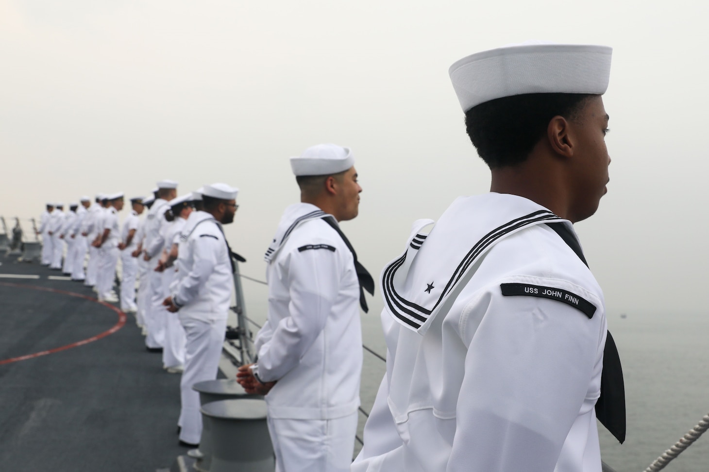 Sailors aboard the Arleigh Burke-class guided-missile destroyer USS John Finn (DDG 113) man the rails during a sea and anchor detail in Jakarta, Indonesia, Aug. 25.