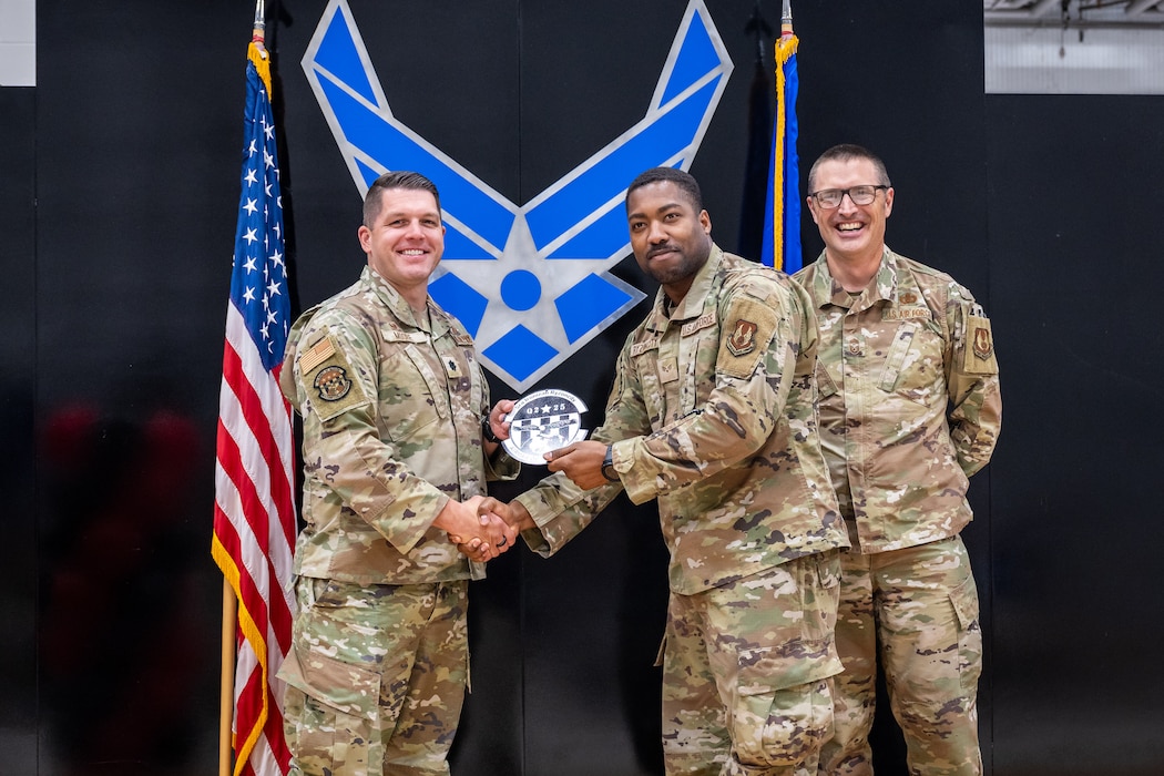 Lt. Col. Juston Moore, commander of the 88th Comptroller Squadron, and Chief Master Sgt. David McCormick pose for a photo with award winner Senior Airman Ironizah Rynoncity of the 88th Comptroller Squadron during the Wing Staff Agency all call at Wright-Patterson Air Force Base, Ohio, Aug. 28, 2025. The event recognized award winners for their contributions throughout the quarter. (U.S. Air Force photo by Daniel Peterson)
