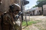 U.S. Air Force Airman Isabel Velazquez, 154th Civil Engineer Squadron emergency management specialist, engages in a simulated combat scenario with U.S. Marines during exercise Toxic Swell Aug. 21, 2025, at Marine Corps Training Area, Bellows Air Force Station, Hawaii. The training developed chemical, biological, radiological, and nuclear response skills and built coordination among U.S. Air Force, Marine Corps, and Royal Australian Air Force teams in dynamic combat environments.