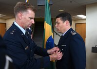 U.S. Air Force Maj. Gen. David Mineau, Air Forces Southern commander, left, awards  Brazilian Air Force Col. Leonardo Macedo, foreign liaison officer, right, the Meritorious Service Medal at Davis-Monthan Air Force Base, Arizona, Sept. 4, 2025. The Brazilian foreign liaison officer holds a special role at AFSOUTH as the relationship between Brazil and the United States is the oldest relationship between the U.S. and the Latin American air forces, dating back to combat operations in World War II. (U.S. Air Force photo by Staff Sgt. Abbey Rieves)