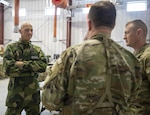Swedish Army Lt. Col. Fredrik Mansson, the chief of operations for the Swedish 1st Division Headquarters, speaks with an officer of the New York National Guard's 42nd Infantry Division during the division’s Warfighter exercise at Fort Indiantown Gap, Pennsylvania, on Feb. 3, 2025. Mansson and other Swedish leaders were visiting the exercise to learn from the New York Guardsmen. From Sept. 16-23, 2025, New York National Guard operations experts will be in Sweden helping Mansson and their other Swedish counterparts conduct their first-ever division-level command post exercise.