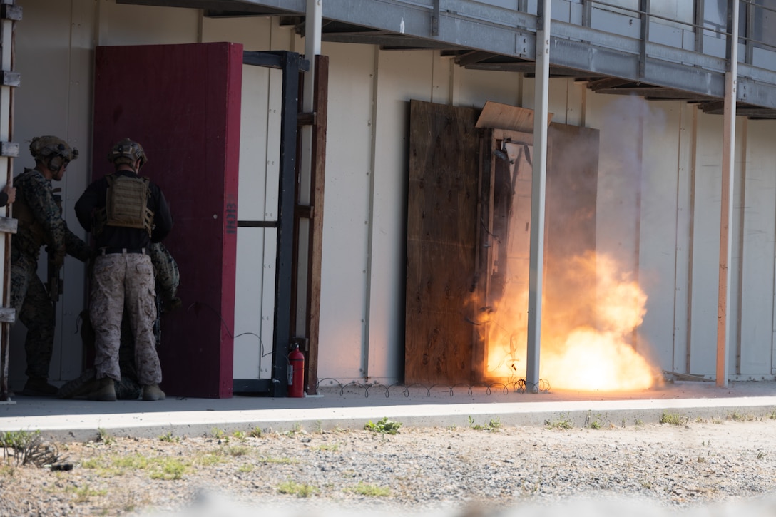 U.S. Marines with 1st Battalion, 1st Marine Regiment, 1st Marine Division, breach through a door while conducting a raid at Camp Pendleton, California, Aug. 14, 2025.