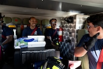 Fire fighters are inside the fire truck chatting before beginning their training mission.