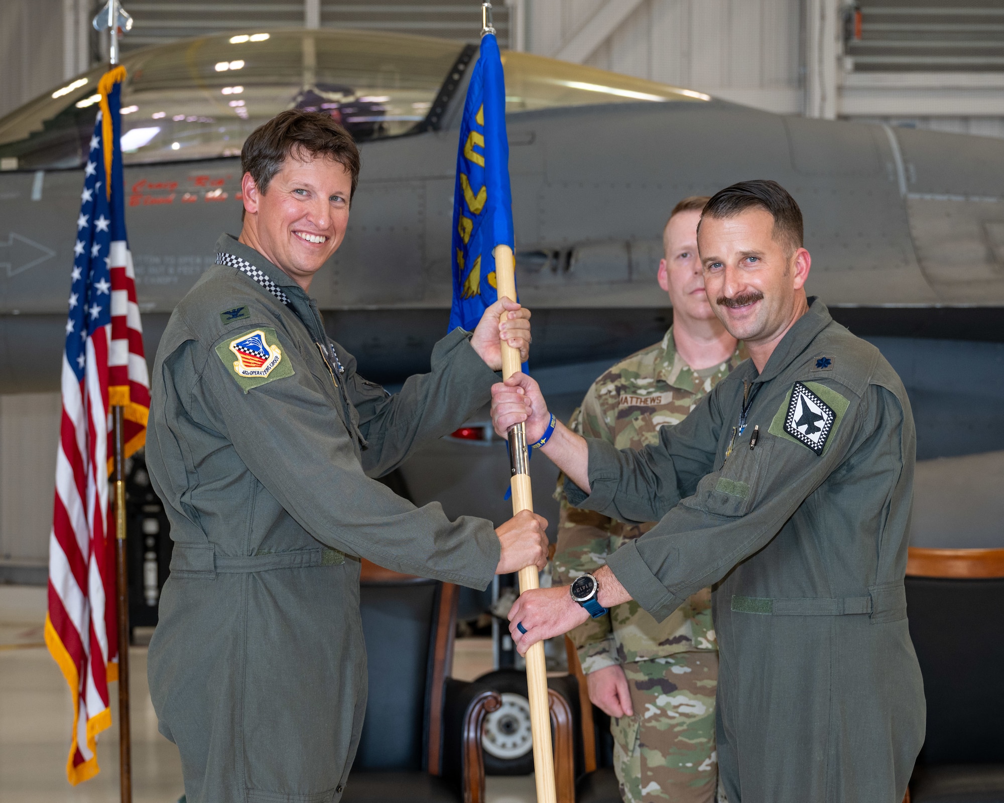 Col. Tavis Powell, 482d Fighter Wing deputy commander, passes the 93d Fighter Squadron guidon to Lt. Col. Evan Erickson during a change of command ceremony at Homestead Air Reserve Base, Florida, Sept. 5, 2025. (U.S. Air Force photo by Master Sgt. Lionel Castellano)