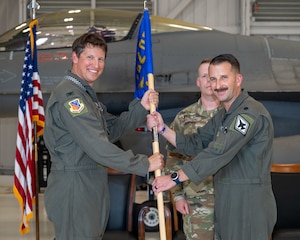 Col. Tavis Powell, 482d Fighter Wing deputy commander, passes the 93d Fighter Squadron guidon to Lt. Col. Evan Erickson during a change of command ceremony at Homestead Air Reserve Base, Florida, Sept. 5, 2025. (U.S. Air Force photo by Master Sgt. Lionel Castellano)