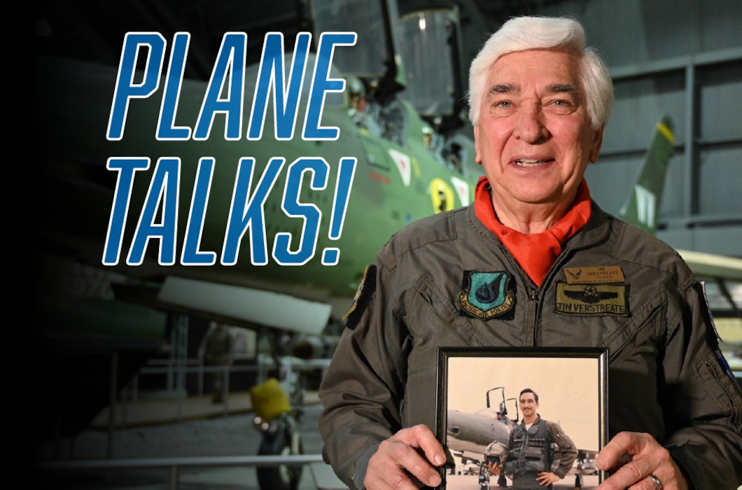 A gentleman standing in front of a Vietnam-era jet holding a photo of himself as a younger man