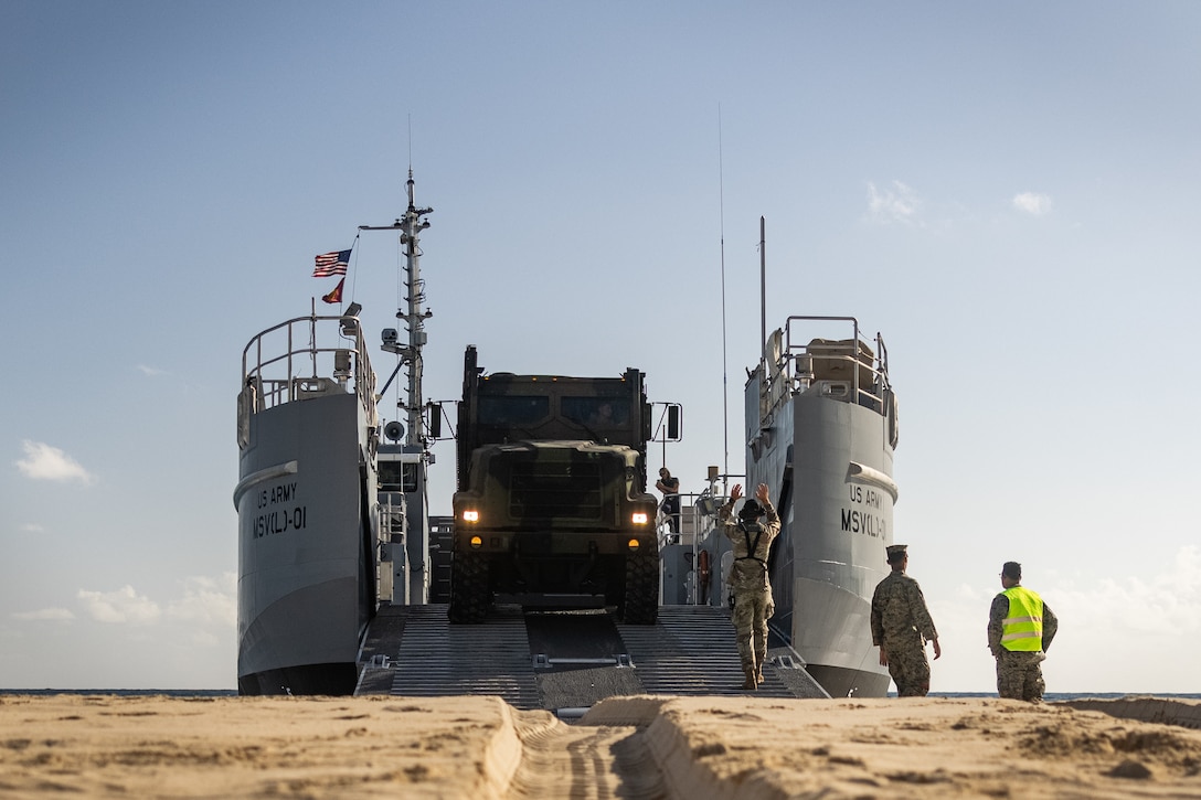 U.S. Marines with 3d Littoral Logistics Battalion (LLB), 3d Marine Littoral Regiment, 3d Marine Division, and U.S. Soldiers with 7th Transportation Brigade onload a Medium Tactical Vehicle Replacement onto a Maneuver Support Vessel (Light) (MSV(L)) on Marine Corps Base Hawaii, Aug. 26, 2025. The purpose of this training was to test the interoperability between the Army’s MSV(L) and Marine Corps equipment, demonstrating the readiness of 3d LLB to adapt to interservice transportation. (U.S. Marine Corps photo by Sgt. Malia Sparks)