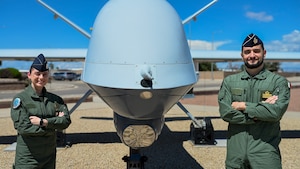 Italian air force Capt. Marco, right, and Senior Master Sgt. Lucia stand in front of an MQ-9 Reaper static display at Holloman Air Force Base, New Mexico, Aug. 28, 2025. Italian air force MQ-9 Reaper trainees refine Remotely Piloted Aircraft tactics with U.S. Air Force instructors, strengthening interoperability and accelerating NATO’s readiness to deliver decisive coalition airpower. (U.S. Air Force photo by Senior Airman Michelle Ferrari)