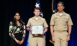 Dr. Merlynn Carson, performing the duties of the Deputy Under Secretary of Defense for Personnel and Readiness, recognizes Chief Jessica Tucker, VAQ-209 Suicide Prevention Program Manager, and Cmdr. Ravi DeSilva, CNAFR Director of Psychological Health, at the 2025 DoD Suicide Prevention Recognition Ceremony.