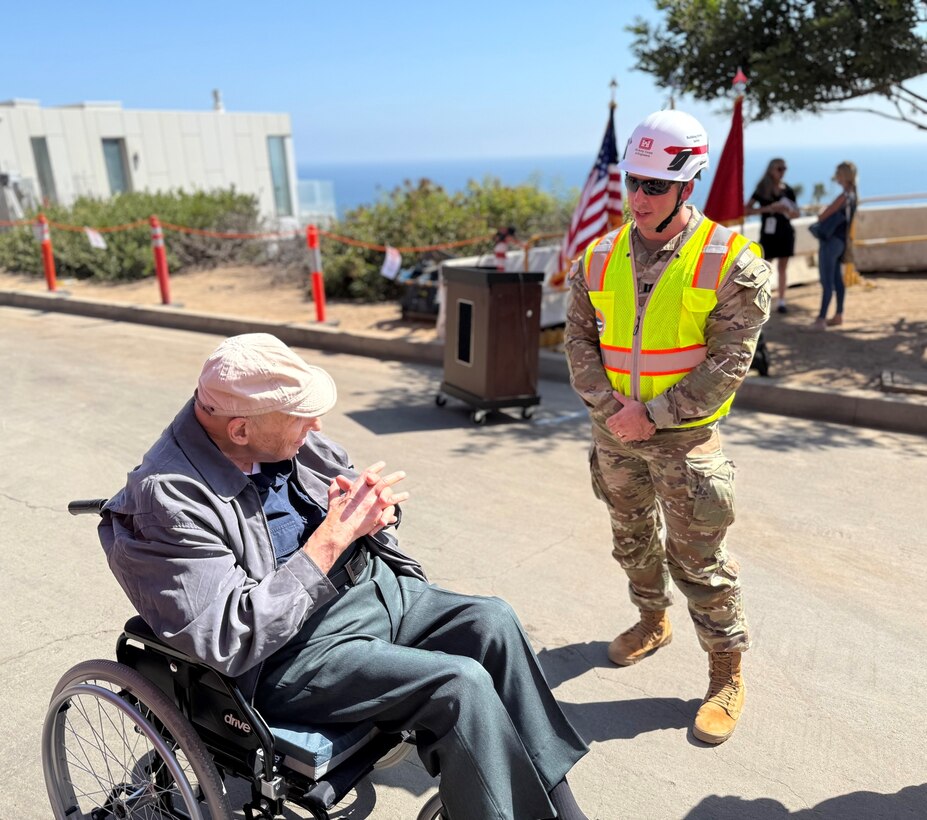 Capt. Zachary Bailey, with the U.S. Army Corps of Engineers Recovery Field Office, talks with Noland West, whose property was the last opt-in private property slated for debris removal, during a milestone event Aug. 26 in the Pacific Palisades neighborhood of Los Angeles.