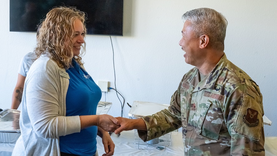U.S. Air Force Maj. Mario Rosario, 5th Bomb Wing (5BW) deputy chaplain, coins Randi Ova, North Star retail branch manager, during the monthly dorm dinner at Minot Air Force Base, North Dakota, Sep. 5, 2025. The event, facilitated by the 5BW Chaplain Corps and Minot Spouses Club, offers Airmen an opportunity to build community, enjoy fellowship, and receive a complimentary dinner in a relaxed setting.