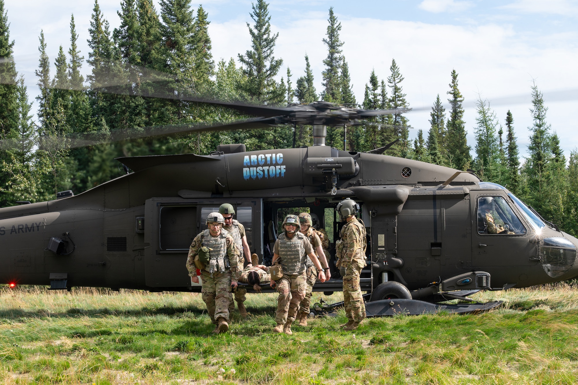 Tactical Combat Casualty Care (TCCC) students from the 168th Wing train on loading and offloading patients from a UH-60 Black Hawk helicopter during an advanced Tactical Combat Casualty Care training.
