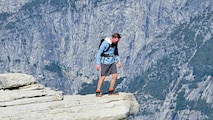U.S. Air Force Tech. Sgt. Ty LaCourse, 48th Intelligence Support Squadron cyber systems operation chief, standing on the edge of a rock on the Half Dome hike at Yosemite National Park, California, June 28, 2025.