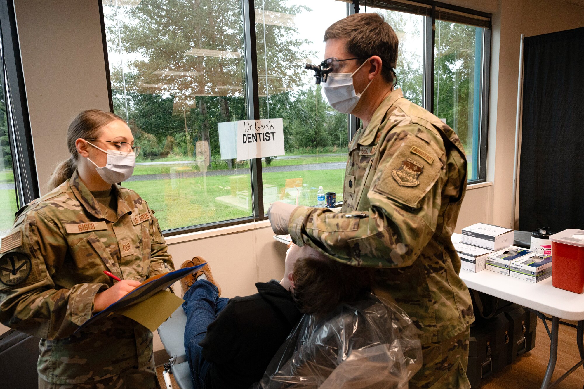U.S. Air National Guard Dentist Jonathan Gerick provides dental care to a Fairbanks Veteran alongside Tech. Sgt. Charity Sisco of the 168th Medical Group.