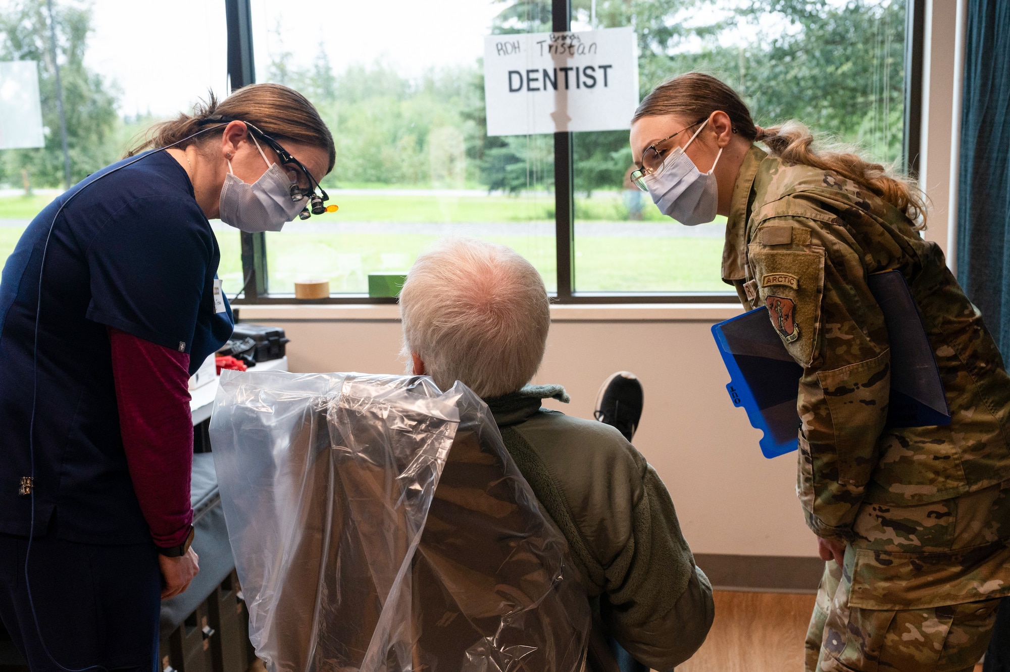 Brandy Tristan, a local registered dental hygienist, talks to a Veteran before performing a dental exam while serving alongside Tech. Sgt. Charity Sisco of the 168th Medical Group, who serves as a dental assistant during the 2025 Veterans Stand Down at the Carlson Center in Fairbanks, Alaska.