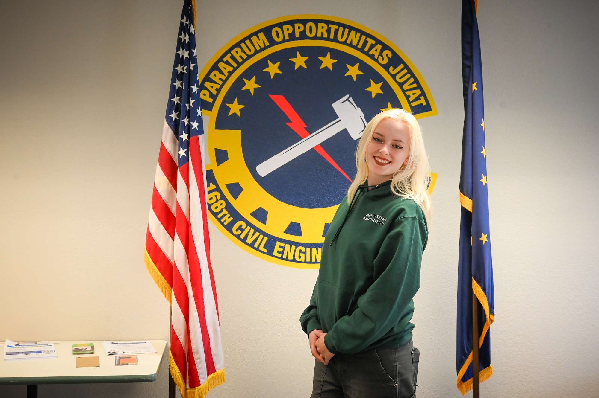 Melaynee White, Miss Fairbanks, poses for a photo in front of the Alaska Air National Guard’s 168th Wing Civil Engineering patch recently painted by her on the wall of the CE building she serves in at Eielson Air Force Base.