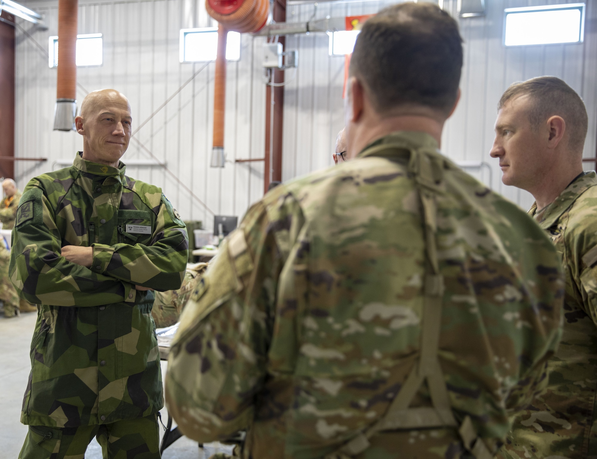 Swedish Army Lt. Col. Fredrik Mansson, the chief of operations for the Swedish 1st Division Headquarters, speaks with an officer of the New York National Guard's 42nd Infantry Division during the division’s Warfighter exercise at Fort Indiantown Gap, Pennsylvania, on Feb. 3, 2025.