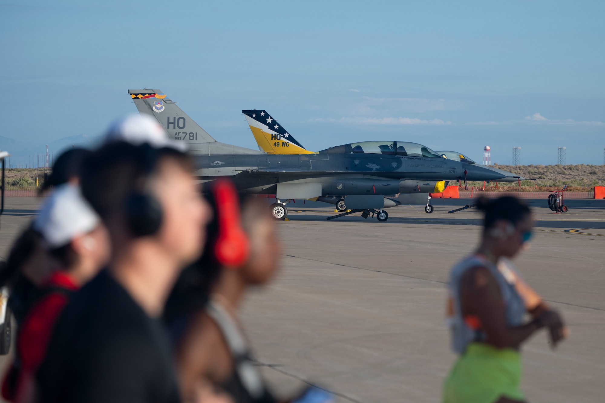 Racers pass the two F-16 Fighting Falcons assigned to the 49th Wing during the 3rd annual Ace of Races Marathon at Holloman Air Force Base, New Mexico, Sept. 6, 2025. The 49th Wing is responsible for training the majority of F-16 pilots and more than half of all MQ-9 Reaper aircrew. (U.S. Air Force photo by Tech. Sgt. Victor J. Caputo)