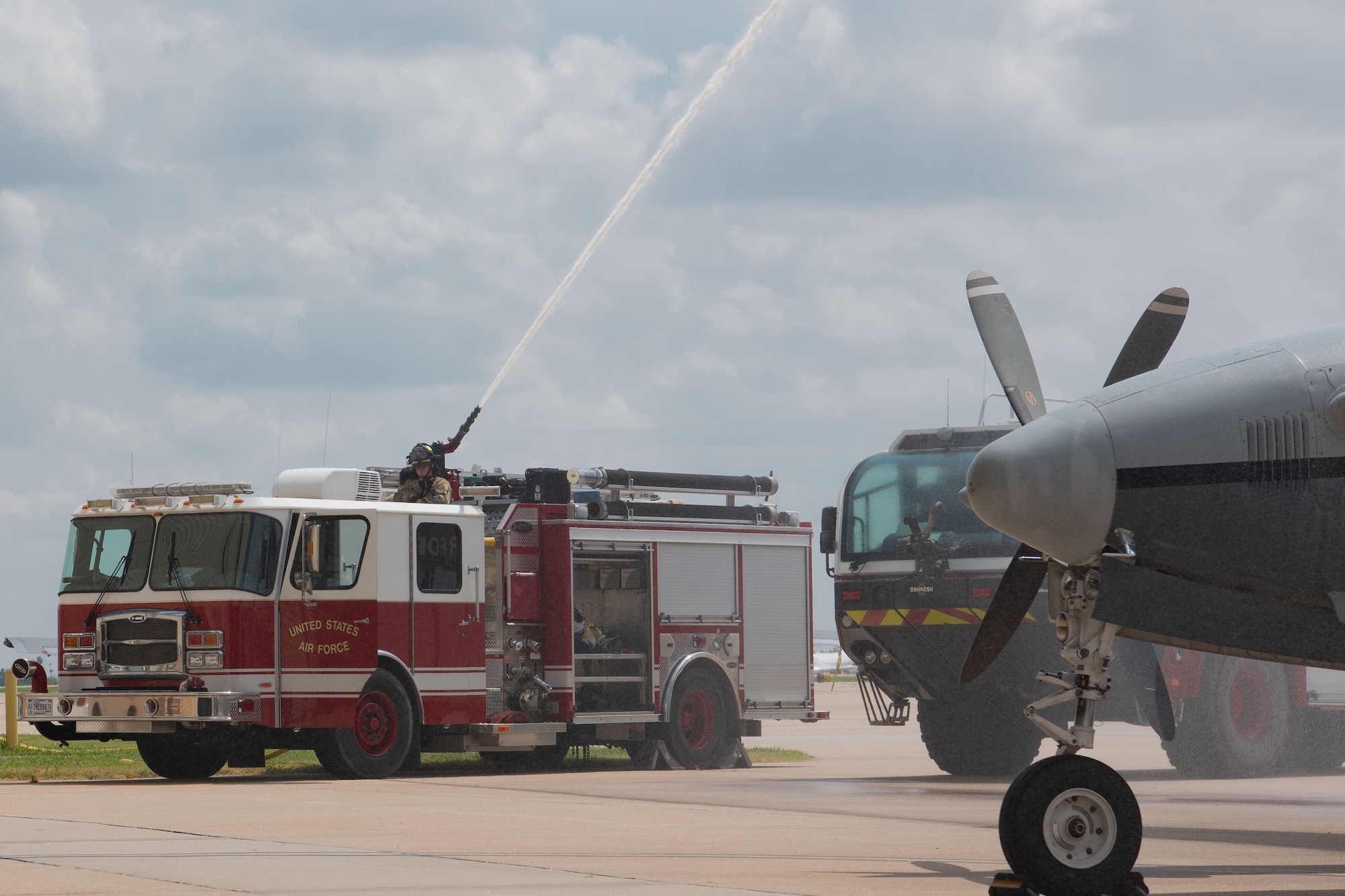 a fire truck sprays water on an aircraft